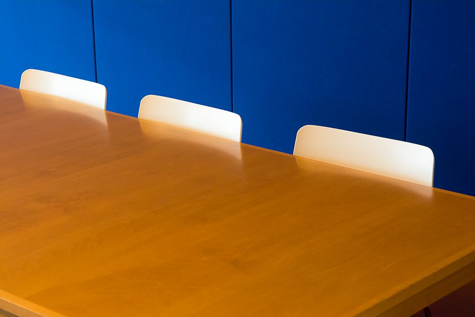 Een moderne witte houten vergadertafel in een lichte kantoorruimte, bevorderlijk voor samenwerking en productiviteit.